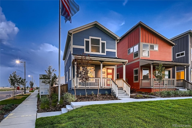 6309 N Hanover St, Denver, CO 80238 - view of front facade featuring covered porch, board and batten siding, and a front lawn
