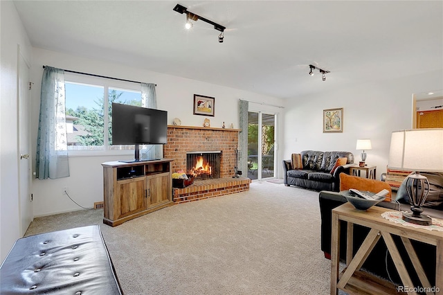 carpeted living room with a fireplace and rail lighting