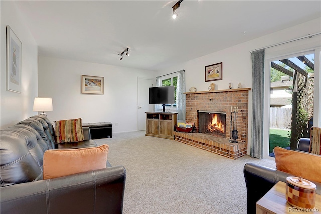 living room featuring a fireplace, carpet floors, and track lighting