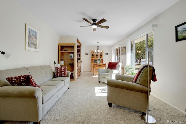 living room featuring ceiling fan with notable chandelier and light carpet