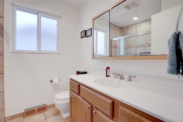 bathroom featuring tile patterned flooring, vanity, toilet, and walk in shower