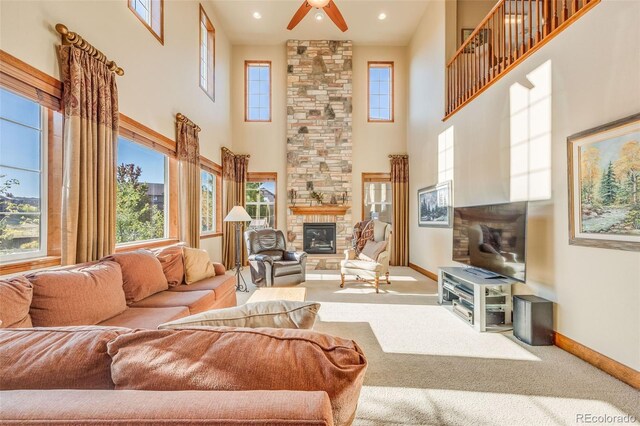 carpeted living room featuring a fireplace, a towering ceiling, and a healthy amount of sunlight