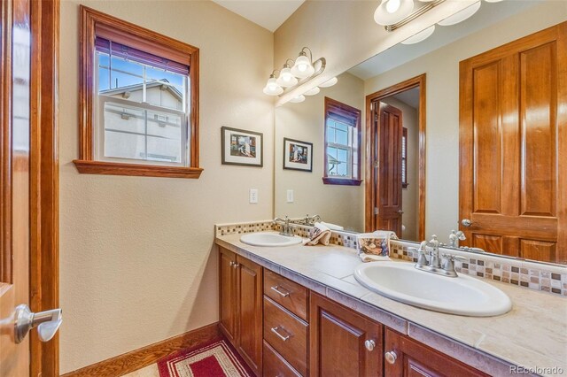 bathroom featuring decorative backsplash, vanity, and a healthy amount of sunlight