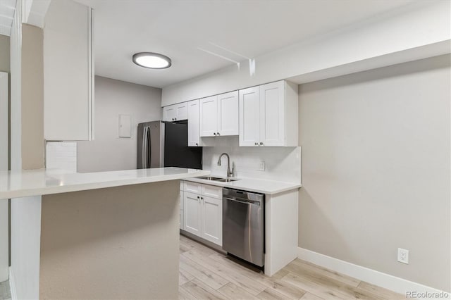 381 S Ames St Unit E104, Lakewood, CO 80226 - kitchen featuring stainless steel appliances, backsplash, white cabinetry, light wood-style floors, and light countertops
