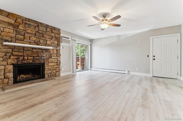 381 S Ames St Unit E104, Lakewood, CO 80226 - unfurnished living room featuring baseboard heating, a ceiling fan, a fireplace, a wall unit AC, and wood finished floors
