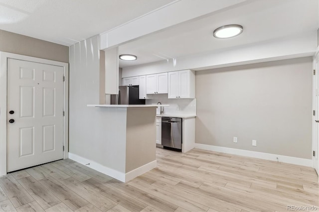 381 S Ames St Unit E104, Lakewood, CO 80226 - kitchen with appliances with stainless steel finishes, light wood finished floors, white cabinetry, light countertops, and backsplash