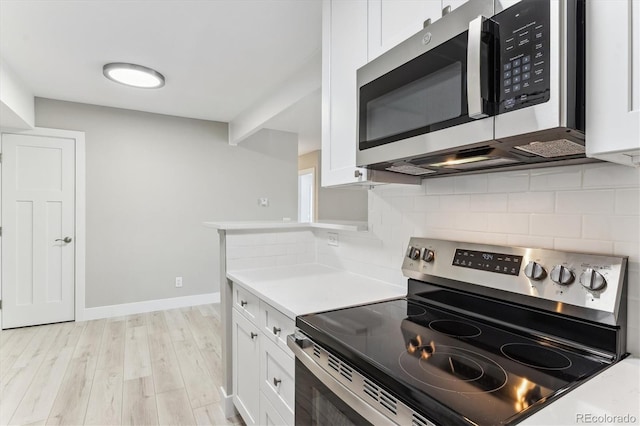381 S Ames St Unit E104, Lakewood, CO 80226 - kitchen featuring appliances with stainless steel finishes, white cabinets, light countertops, tasteful backsplash, and light wood-type flooring