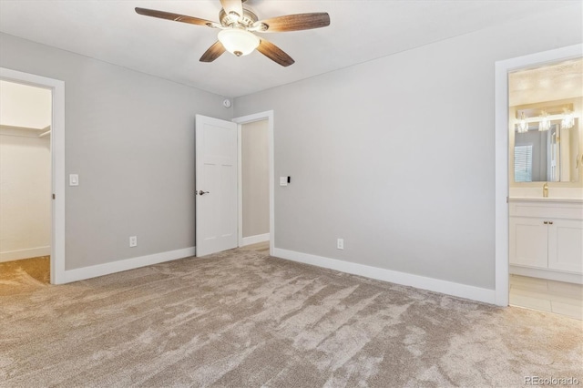 381 S Ames St Unit E104, Lakewood, CO 80226 - unfurnished bedroom featuring a walk in closet, light colored carpet, ensuite bath, a ceiling fan, and a closet