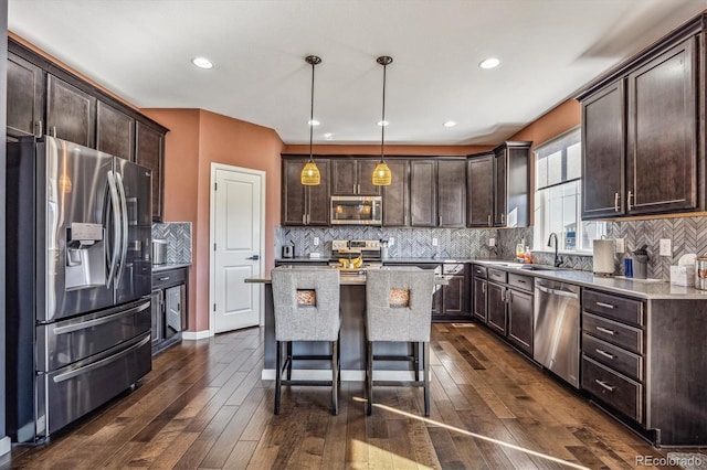 kitchen featuring stainless steel appliances, dark hardwood / wood-style flooring, pendant lighting, and a kitchen island