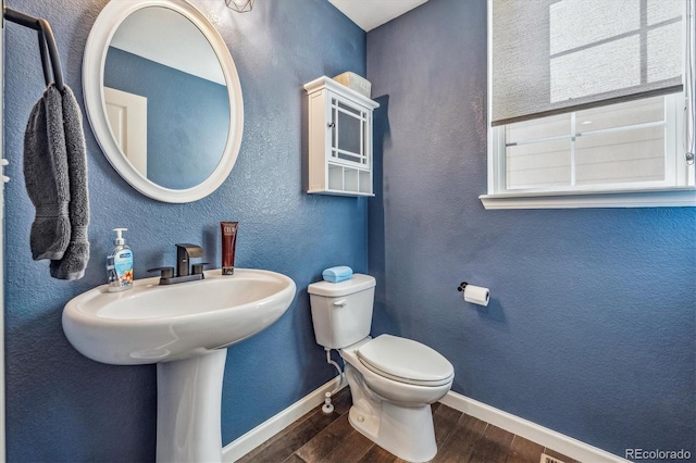 bathroom featuring wood-type flooring and toilet