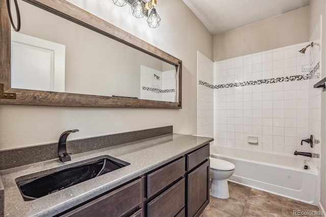 full bathroom featuring vanity, toilet, tile patterned floors, and tiled shower / bath