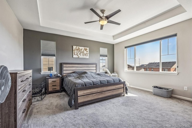 bedroom featuring ceiling fan, a raised ceiling, and carpet