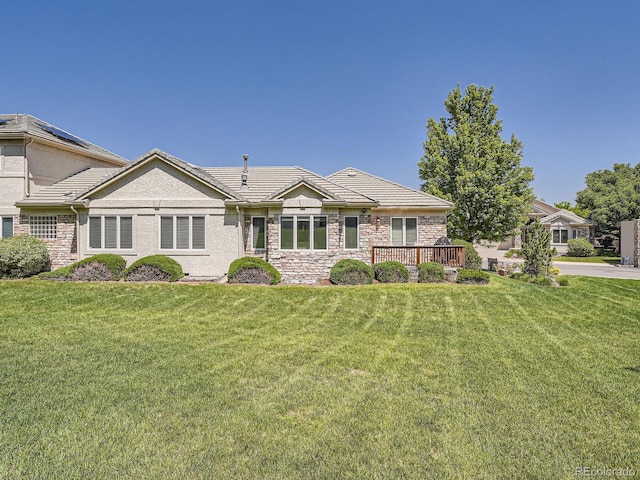 14064 E Whitaker Dr, Aurora, CO 80015 - view of front of property with a tiled roof, a front lawn, a wooden deck, and stone siding