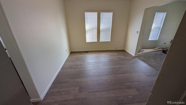 empty room with dark hardwood / wood-style flooring