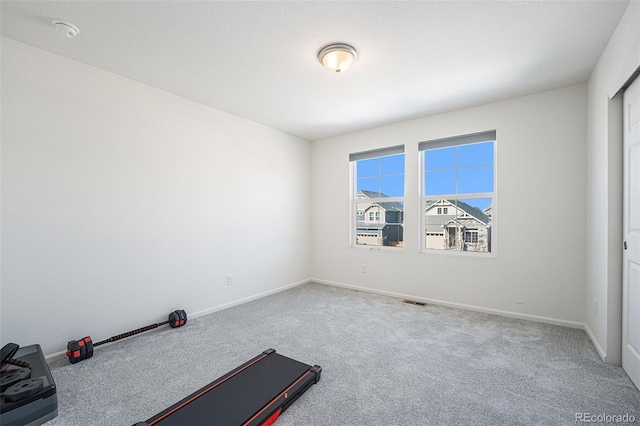 workout room with carpet floors, visible vents, and baseboards