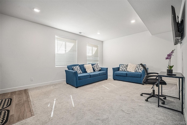 living room featuring recessed lighting, a textured ceiling, and baseboards