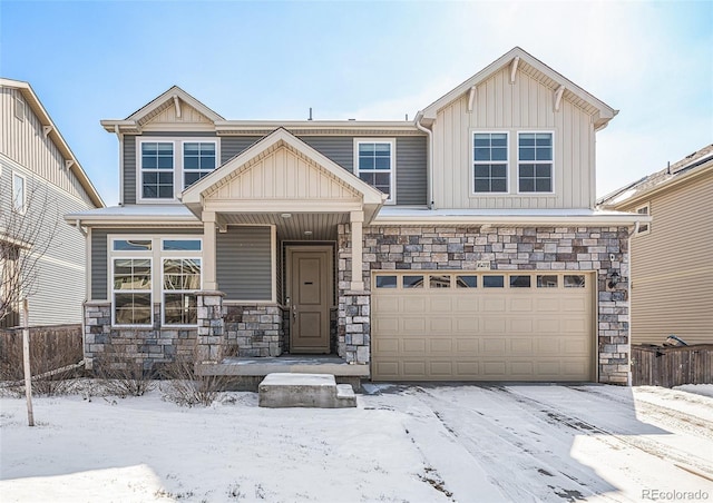 view of front of house with stone siding, board and batten siding, an attached garage, and fence