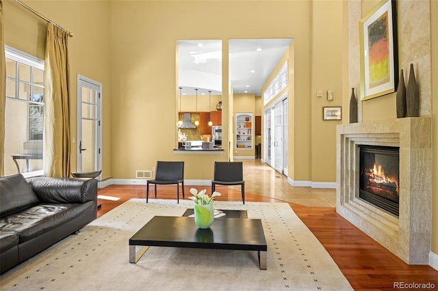 living room featuring light hardwood / wood-style flooring and a tiled fireplace