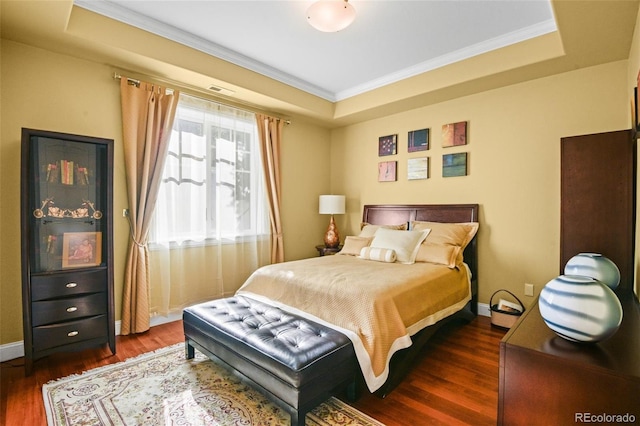 bedroom featuring a tray ceiling, dark hardwood / wood-style floors, and ornamental molding