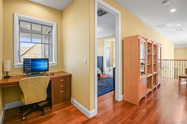 office area with built in desk and hardwood / wood-style flooring