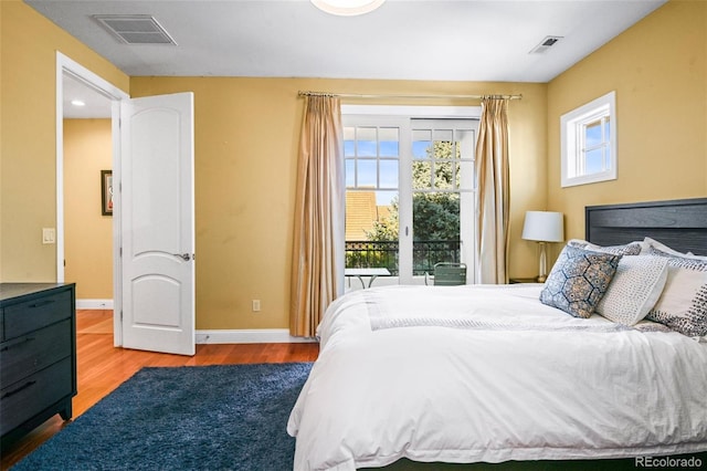 bedroom featuring multiple windows and hardwood / wood-style floors