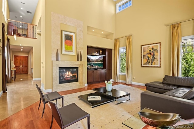 living room featuring light hardwood / wood-style floors and a high ceiling