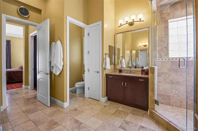 bathroom with tile patterned floors, a shower with door, vanity, and toilet