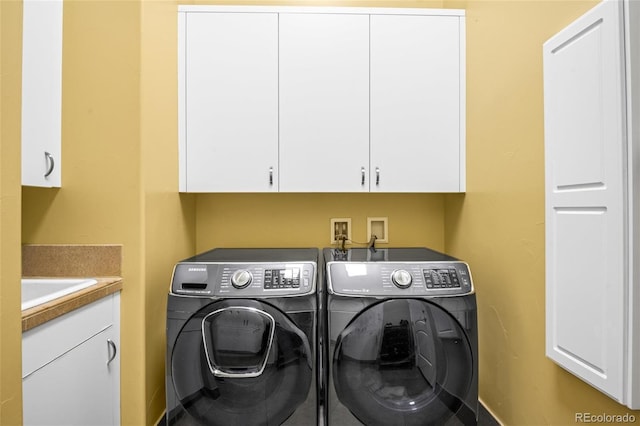 washroom featuring washer and clothes dryer and cabinets