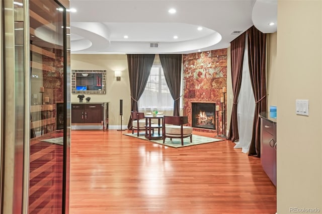 unfurnished room with visible vents, baseboards, wood finished floors, a fireplace, and recessed lighting