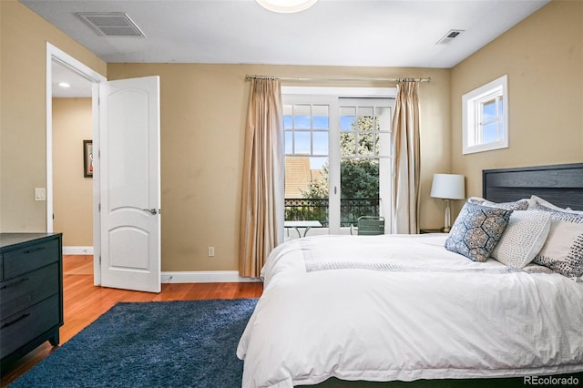 bedroom featuring wood finished floors, visible vents, and baseboards