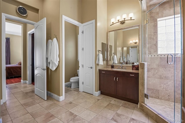 bathroom with toilet, a shower stall, baseboards, and tile patterned floors