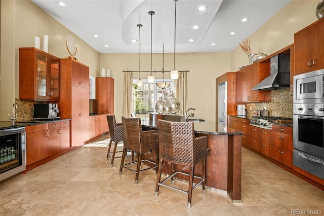 kitchen with built in appliances, wine cooler, a warming drawer, wall chimney exhaust hood, and glass insert cabinets