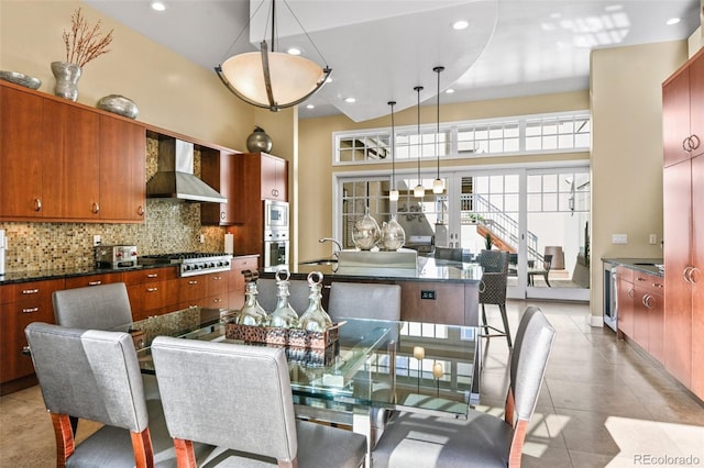 dining room with a high ceiling, light tile patterned flooring, and recessed lighting