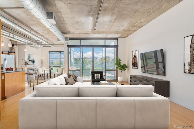 living area with light wood-type flooring and baseboards