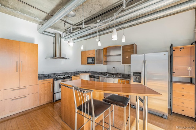 kitchen featuring pendant lighting, sink, stainless steel appliances, range hood, and light hardwood / wood-style floors