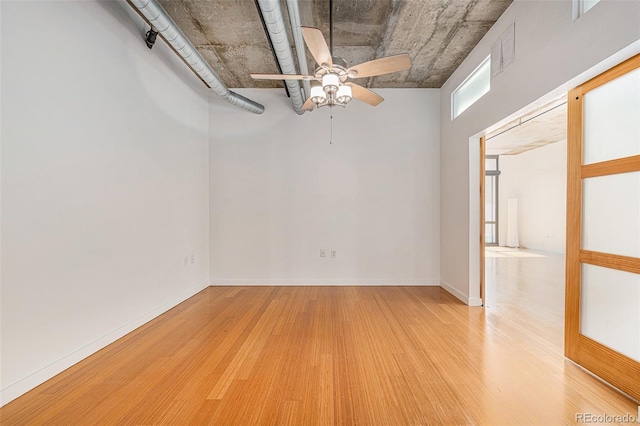 unfurnished room featuring light wood-type flooring, baseboards, a ceiling fan, and visible vents