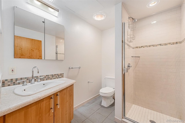 bathroom with tile patterned floors, vanity, toilet, and a shower with shower door