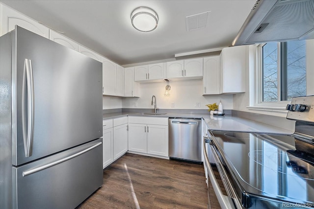 kitchen featuring dark wood-type flooring, sink, white cabinetry, appliances with stainless steel finishes, and wall chimney range hood