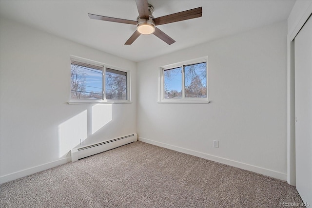 carpeted empty room with a baseboard heating unit and ceiling fan