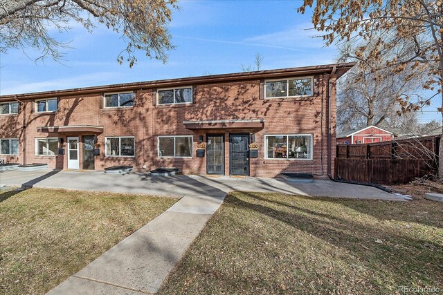 view of property featuring a patio area and a front lawn