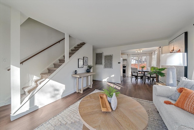 living room featuring a notable chandelier and dark wood-type flooring