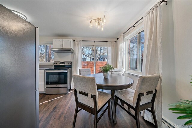 dining area featuring dark hardwood / wood-style floors, an inviting chandelier, and baseboard heating