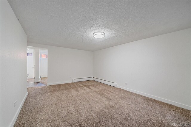 carpeted spare room with a textured ceiling and baseboard heating