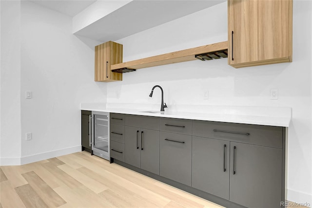 300 S Franklin St, Denver, CO 80209 - kitchen featuring beverage cooler, open shelves, gray cabinetry, light wood-style floors, and light countertops