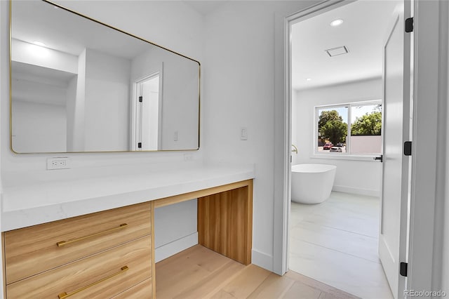 300 S Franklin St, Denver, CO 80209 - bathroom featuring vanity, a soaking tub, recessed lighting, and wood finished floors