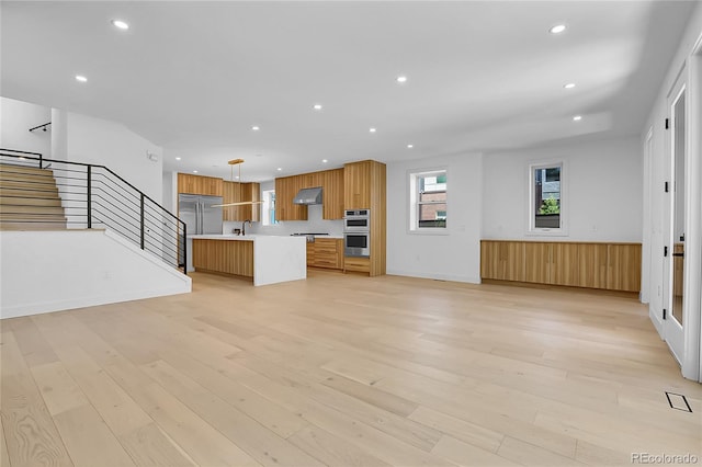 300 S Franklin St, Denver, CO 80209 - kitchen with light countertops, stainless steel appliances, open floor plan, under cabinet range hood, and light wood-type flooring