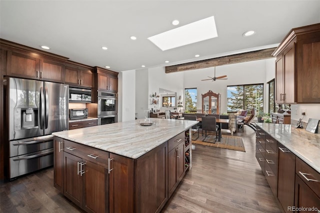 8453 S Scenic Dr, Morrison, CO 80465 - kitchen featuring stainless steel appliances, a skylight, recessed lighting, dark wood-type flooring, and light stone countertops