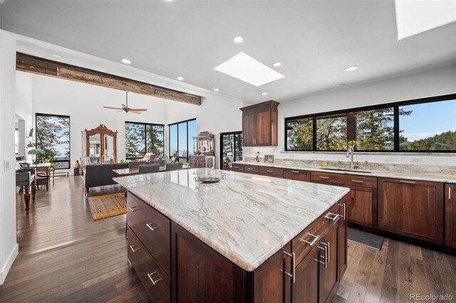 8453 S Scenic Dr, Morrison, CO 80465 - kitchen with a sink, a skylight, recessed lighting, light stone counters, and dark wood-type flooring