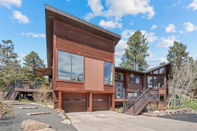 8453 S Scenic Dr, Morrison, CO 80465 - view of front of home with stairs, a wooden deck, an attached garage, and driveway