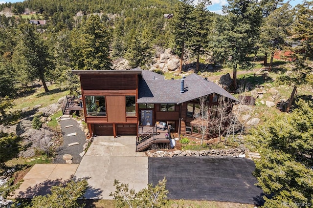 8453 S Scenic Dr, Morrison, CO 80465 - view of front of house featuring stairway, a porch, a wooded view, a shingled roof, and an attached garage